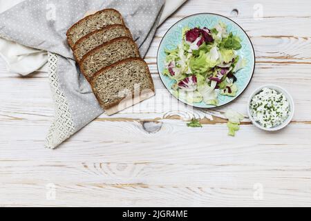 Ein Gemüsesalat und Brotscheiben auf dem Tisch. Gesunde Ernährung Stockfoto