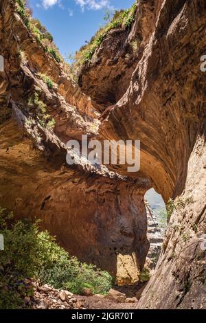 Blick mit einem Fenster zwischen den Felsen auf der Echo Ravine Wanderung im Golden Gate Highlands National Park in der Nähe von Clarens, Südafrika Stockfoto