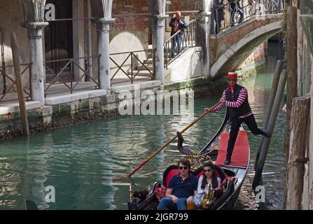 VENEDIG, ITALIEN - 21. APRIL 2019 venezianischer Gondoliere, der mit dem Fuß abschiebt Stockfoto