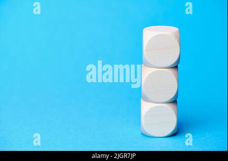 Stapel von drei Holzwürfeln auf blauem Hintergrund Stockfoto