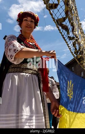 Krakau, Polen. 12.. Juli 2022. Ukrainische Frau posiert mit ukrainischer Flagge während einer Zeremonie, die einem Platz in der Altstadt von Krakau, Polen, am 12. Juli 2022 den Namen Unabhängige Ukraine verleiht. Die lokale Regierung betont, dass sie die Entscheidung getroffen hat, Unterstützung und Einheit mit dem ukrainischen Volk zu zeigen. Der Ort für den ukrainischen Unabhängigkeitsplatz wurde bewusst in unmittelbarer Nähe des russischen Konsulats in Krakau gewählt. (Foto von Dominika Zarzycka/Sipa USA) Quelle: SIPA USA/Alamy Live News Stockfoto