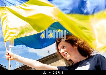 Krakau, Polen. 12.. Juli 2022. Die ukrainische junge Frau hält ukrainische und EU-Flaggen während einer Zeremonie, die einem Platz in der Altstadt von Krakau, Polen, am 12. Juli 2022 den Namen Unabhängige Ukraine verleiht. Die lokale Regierung betont, dass sie die Entscheidung getroffen hat, Unterstützung und Einheit mit dem ukrainischen Volk zu zeigen. Der Ort für den ukrainischen Unabhängigkeitsplatz wurde bewusst in unmittelbarer Nähe des russischen Konsulats in Krakau gewählt. (Foto von Dominika Zarzycka/Sipa USA) Quelle: SIPA USA/Alamy Live News Stockfoto