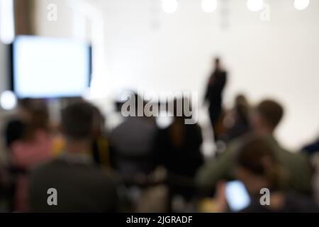 Verschwommener Hintergrund der Geschäftskonferenz, ein Mann auf der Bühne, Präsentation des Projekts, öffentlicher Vortrag. Hochwertige Fotos Stockfoto