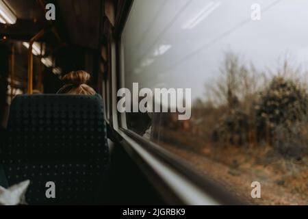 Eine selektive Fokusaufnahme eines Sitzes neben dem Glasfenster eines öffentlichen Fahrzeugs Stockfoto