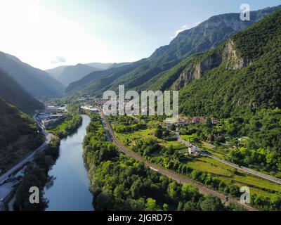 Eine Aufnahme aus einem hohen Winkel eines schönen Dorfes, umgeben von Wäldern und Hügeln und einem Fluss im Tal Stockfoto