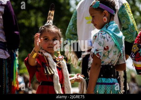 Kahnawake, Kanada. 10.. Juli 2022. Kinder warten während des Festivals in der Arena auf ihre Runde. Die jährlichen Echoes of a Proud Nation Pow-Wow 30. brachten Tausende von Menschen aus ganz Nordamerika ein, um die Kultur und Traditionen der Ureinwohner im Mohawk Reserve von Kahnawake zu feiern. Nach einer zweijährigen Pause bot der größte Pow-Wow in Quebec eine Zeit zum Treffen, Tanzen, Singen, Besuchen und Feiern mit Freunden und Familie. Kredit: SOPA Images Limited/Alamy Live Nachrichten Stockfoto