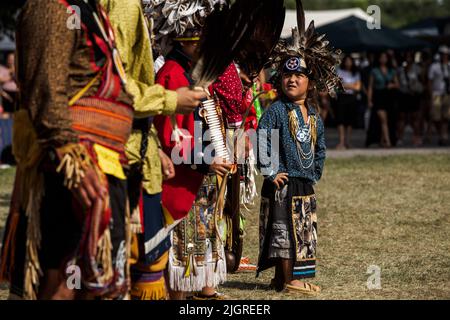 Kahnawake, Kanada. 10.. Juli 2022. Teilnehmer der Pow-Wow warten auf das Urteil des Richters während des Festivals. Die jährlichen Echoes of a Proud Nation Pow-Wow 30. brachten Tausende von Menschen aus ganz Nordamerika ein, um die Kultur und Traditionen der Ureinwohner im Mohawk Reserve von Kahnawake zu feiern. Nach einer zweijährigen Pause bot der größte Pow-Wow in Quebec eine Zeit zum Treffen, Tanzen, Singen, Besuchen und Feiern mit Freunden und Familie. Kredit: SOPA Images Limited/Alamy Live Nachrichten Stockfoto