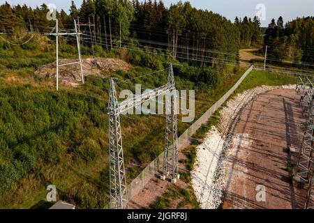 Drohne inspiziert Stromleitungen und Details einer elektrischen Kraftwerksanlage - Luftaufnahme Stockfoto
