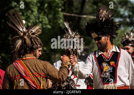 Kahnawake, Kanada. 10.. Juli 2022. POW-Wow-Teilnehmer gratulieren sich nach einer Präsentation. Die jährlichen Echoes of a Proud Nation Pow-Wow 30. brachten Tausende von Menschen aus ganz Nordamerika ein, um die Kultur und Traditionen der Ureinwohner im Mohawk Reserve von Kahnawake zu feiern. Nach einer zweijährigen Pause bot der größte Pow-Wow in Quebec eine Zeit zum Treffen, Tanzen, Singen, Besuchen und Feiern mit Freunden und Familie. (Foto: Giordanno Brumas/SOPA Images/Sipa USA) Quelle: SIPA USA/Alamy Live News Stockfoto