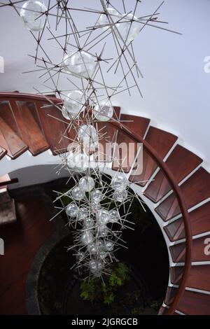 Eine vertikale Aufnahme einer Innenansicht eines Gebäudes mit Holztreppen und einer in der Luft hängenden Lampe Stockfoto