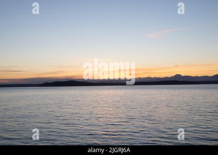 Ein malerischer Blick auf einen See gegen eine Bergkette bei Sonnenuntergang Stockfoto