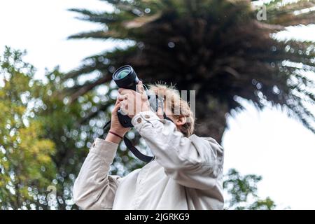 Blonde Reisende Mann, der ein Bild in der Natur Stockfoto