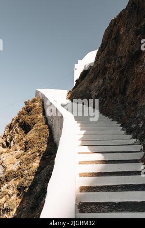 Eine vertikale Aufnahme von weißen Treppen, die zu einem Gebäude auf einem Hügel führen Stockfoto