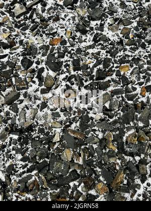 Eine vertikale Aufnahme von Felsen, die teilweise mit leichtem Schnee bedeckt sind Stockfoto