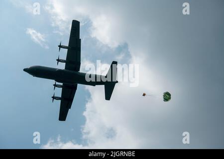 Ein preisgünstiges, in geringer Höhe gelegenes Paket fällt aus einer 36. Airlift Squadron C-130J Hercules in der Bringin Drop Zone auf der Abdulrachman Saleh Air Force Base, Malang, Indonesien, für Cope West 2022, 21. Juni 2022. Cope West 2022 soll die Zusammenarbeit und Interoperabilität zwischen den Luftstreitkräften der USA und Indonesiens im Bereich Luftbrücke ausüben und die Stabilität der Region durch Beziehungsaufbau und Zweckbindung fördern. (USA Foto der Luftwaffe von Staff Sgt. Braden Anderson) Stockfoto