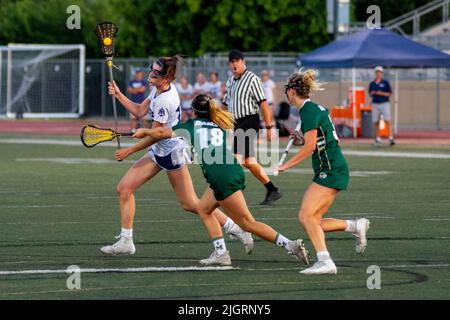 High School Mädchen spielen ein temperamentvoll gelassenes Lacrosse Spiel in einem Downey, CA, Stadion. Stockfoto