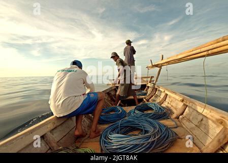 Waljäger auf einem traditionellen Walfangboot, das mit Bambusharpunen und Seilen ausgestattet ist und auf der Savu-See vor der Küste von Lamalera in Wulandoni, Lembata, East Nusa Tenggara, Indonesien, segelt. Stockfoto