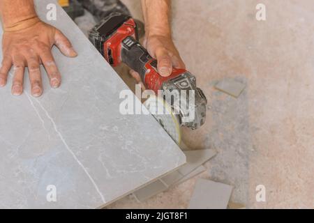 Winkelschleifer Polierscheibe mit Diamant wird vom Arbeiter zum Polieren der geschnittenen Eckfliesen verwendet Stockfoto