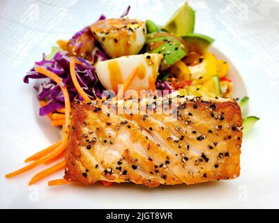 Gegrillter Lachs mit gekochten Eiern, Avocado, Salat, Erbsen, Tomaten und Karotten Stockfoto