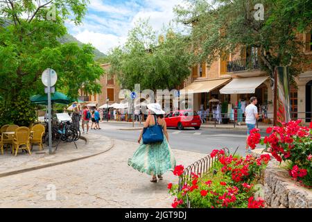 Eine der vielen malerischen, von Bäumen gesäumten Straßen mit Geschäften und Cafés im Dorf Valldemossa, Spanien, auf der Insel Mallorca, Spanien. Stockfoto