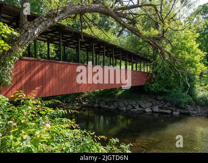 Überdachte Brücke über einen Bach auf einem Wanderweg Stockfoto