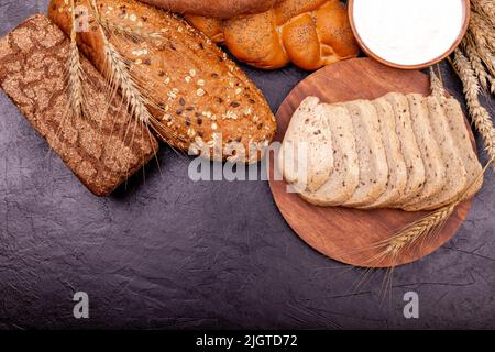 Draufsicht auf Vollkornbrot auf dunklem ruktischem Holzhintergrund Nahaufnahme. Stockfoto