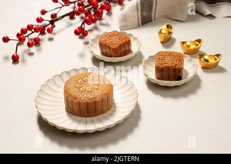 Chinesische traditionelle Konditorei Mondkuchen auf Keramikplatte auf Holzhintergrund für Mid Autumn Festival, Copy Space Stockfoto