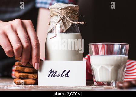 Frau mit Karte in der Nähe einer Flasche Milch Stockfoto