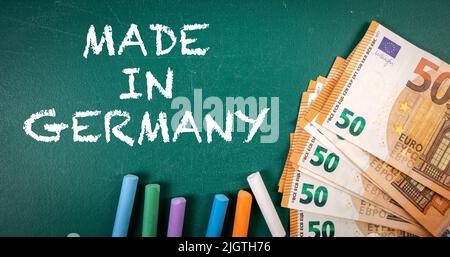HERGESTELLT IN DEUTSCHLAND. Euro-Geld auf einer grünen Tafel. Stockfoto