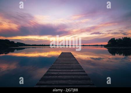 Farbenfrohe Sonnenuntergänge über einem schönen ruhigen See. Hochwertige Fotos Stockfoto