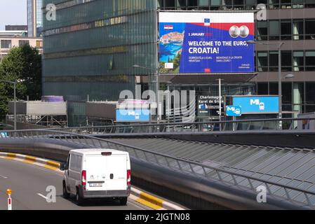 Brüssel, Den 12. 1. Januar 2023. Ein Fahrzeug fährt an einem Plakat vorbei, auf dem steht: „Willkommen beim Euro, Kroatien!“ In Brüssel, Belgien, 12. Juli 2022. Der kroatische Ministerpräsident Andrej Plenkovic begrüßte am Dienstag die Entscheidung des Rates für Wirtschaft und Finanzen der Europäischen Union (ECOFIN), Kroatien am 1. Januar 2023 in die Eurozone zu integrieren. Quelle: Zheng Huansong/Xinhua/Alamy Live News Stockfoto