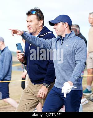 Der nordirische Rory McIlroy (rechts) und der ehemalige Golfer Sir Nick Faldo diskutierten während des 4. Trainingstages der Open auf dem Old Course, St Andrews, über den Fairway 13.. Bilddatum: Mittwoch, 13. Juli 2022. Stockfoto