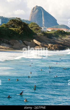 Surfer fangen eine Welle am Strand von der Paco in Rio de Janeiroim Hintergrund der Zuckerhut Stockfoto