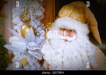 Stilvolles Weihnachtsmann-Porträt trägt weihnachtliches gelb-goldenes Kostüm im Retro-Stil und fabelhaften weißen Bart Stockfoto