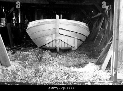 Geschrieben auf der Rückseite: '4.' Die Bilderserie aus einer holländischen Kleinbootrunde 0908-0930. Ein Bootsrumpf in einem Bootsschuppen mit offenen Toren. Stockfoto