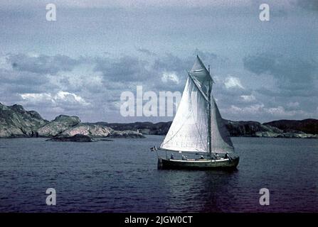 Nach Angaben: 70 St. Ramed-Folie. + 5 Stück Dosen mit oramadeier Folie. Boote, Werften, Meer, Menschen.Film-Nr. 127 Ein Segelboot fährt in einer Meeresbucht. Stockfoto