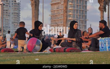 Während des muslimischen Feiertages von Eid al-Adha am 11. Juli 2022 in Tel Aviv, Israel, versammeln sich Palästinenser im Strandpark von Charles Clore. Israelische Behörden erlaubten den Palästinensern im Westjordanland, Tel Aviv und andere Orte in Israel während des Eid al-Adha-Urlaubs zu besuchen. Stockfoto