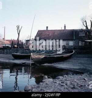 Drei Boote werden an einem Strand in Betrieb genommen. Oberhalb des Strandes befindet sich das Wohnhaus. Foto aus Dänemark (?), Deutschland (?). Stockfoto