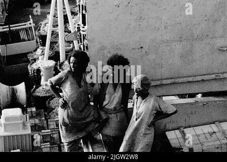African trip, Port Sudden Acquisition: Bücher und Archivmaterial.36 Bilder in Serien. Das Foto wurde ungefähr 1961-08-22 aufgenommen. Zwei einheimische Männer und eine Frau (?) Stellen Sie sich an eine der Ladeluken auf einem Schiff. Stockfoto