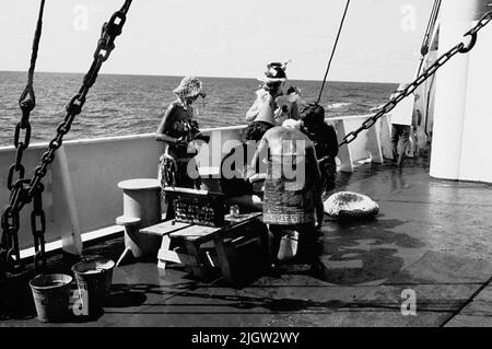 Das Foto wurde ungefähr 1961-09-02 aufgenommen. Linie für diejenigen, die den Äquator zum ersten Mal passieren. An Deck ist eine Szene vorbereitet. Ein Mann, der als Polizeibeamter gekleidet ist, schreit seine Befehle in einem Megaphon zu seinen "Gefangenen". Afrikanreise, Aden Linjedop.36 Bilder in Serie. Stockfoto