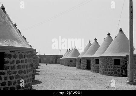 African trip, Port Sudden Acquisition: Bücher und Archivmaterial.36 Bilder in Serien. Das Foto wurde ungefähr 1961-08-22 aufgenommen. Runde, ummauerte Wohngebäude mit spitzen Zementdächern. Die Häuser sind auf dem Weg. Stockfoto