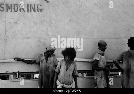 African trip, Port Sudden Acquisition: Bücher und Archivmaterial.36 Bilder in Serien. Das Foto wurde ungefähr 1961-08-22 aufgenommen. Vier einheimische Männer an einem der Ladungsluken auf einem Schiff. Stockfoto