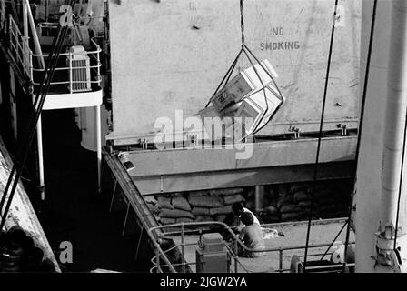 African trip, Port Sudden Acquisition: Bücher und Archivmaterial.36 Bilder in Serien. Das Foto wurde ungefähr 1961-08-22 aufgenommen. Ein Kran entladen oder entladen Waren von einem Schiff in einem Hafen. Stockfoto