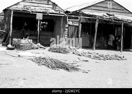 African trip, Port Sudden Acquisition: Bücher und Archivmaterial.36 Bilder in Serien. Das Foto wurde ungefähr 1961-08-22 aufgenommen. Zwei Geschäfte in einer Gemeinde. Ein paar Männer sitzen in den Geschäften. Stockfoto