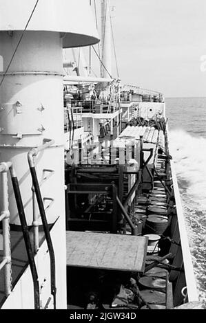 Afrikanische Reise, Arbeit an Bord. Squal Akquisitionen: Bücher und Archivmaterial.35 Bilder in Serien. Das Foto wurde ungefähr 1961-08-03 aufgenommen. Ein Schiff auf dem Weg zu einem Hafen. Ein Teil der Ladung ist an Bord des Reifens sichtbar. Unter anderem sind Ölfässer sichtbar. Stockfoto