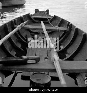 2. Die Niederlande, Frankreich. Photo Journal ist erhältlich bei B.M.A. + Fotoalben. Erwerb: Bücher und Archivmaterial. Fotos aufgenommen zwischen 1959-10-12. Und 1959-10-16,12 Bilder in Serie. Laut Notizen: Niederlande, Dortse Kil/Waal 12/10-59. Flachbodenboot, älteres Holzboot. Außen und innen. Im Heck zur Befestigung des Außenbordmotors. Ein Boot befindet sich an einem Strand. Im Boot befinden sich zwei Ruder sowie eine Insel aus Holz. Auf dem Boden steht ein Tellereimer mit Deckel. Auf der linken Seite ist ein weiteres Boot. Stockfoto