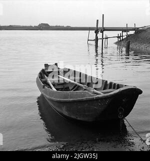 2. Die Niederlande, Frankreich. Fotojournal ist bei B.M.A. erhältlich + Fotoalben. Erwerb: Bücher und Archivmaterial. Fotos aufgenommen zwischen 1959-10-12. Und 1959-10-16,12 Bilder in Serie. Laut Notizen: Niederlande, Dortse Kil/Waal 12/10-59. Flachbodenboot, älteres Holzboot. Außen und innen. Im Heck zur Befestigung des Außenbordmotors. Ein Boot befindet sich an einem Strand. Im Boot sind zwei Jahre. Auf der rechten Seite befindet sich ein Steg. Stockfoto