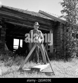 14. Schweden, Italien. Fotojournal ist bei B.M.A. erhältlich + Fotoalben. Erwerb: Bücher und Archivmaterial. Fotos aufgenommen 1959-10-28,12 Bilder in Serie. Laut Notizen: Schweden. 20/10 -59 ca. Steht Ein Mann vor einem Nebengebäude, mit einer Schablone an der Stange auf einem Boot. Stockfoto