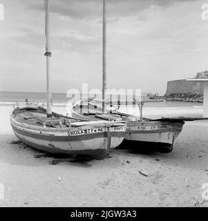 14. Schweden, Italien. Fotojournal ist bei B.M.A. erhältlich + Fotoalben. Erwerb: Bücher und Archivmaterial. Fotos aufgenommen 1959-10-28,12 Bilder in Serie. Nach Angaben: Italien. Adriaküste, Thermoli, 28/10 -59. Überdachte und unbedeckte Fischerboote mit lateinischen Rigs, die am Strand in Betrieb genommen wurden. Zwei Fischerboote befinden sich an einem Sandstrand. Draußen ist ein offenes Meer. Rechts ist eine Mauer am Wasser. Stockfoto