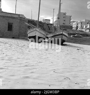 14. Schweden, Italien. Fotojournal ist bei B.M.A. erhältlich + Fotoalben. Erwerb: Bücher und Archivmaterial. Fotos aufgenommen 1959-10-28,12 Bilder in Serie. Nach Angaben: Italien. Adriaküste, Thermoli, 28/10 -59. Überdachte und unbedeckte Fischerboote mit lateinischen Rigs, die am Strand in Betrieb genommen wurden. Zwei Boote befinden sich an einem Strand. Dahinter liegt eine Gemeinde etwas auf einem Hügel. Stockfoto
